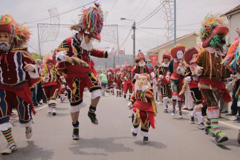 Bugios mascarados a dançar pela rua durante a Bugiada de Sobrado