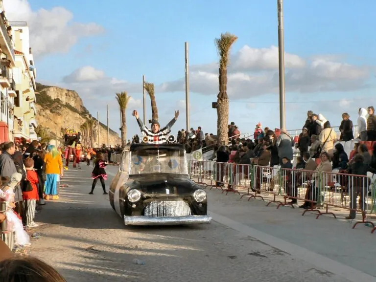 Carro mascarado a desfilar na Avenida dos Náufragos, entre o público, no Carnaval de Sesimbra