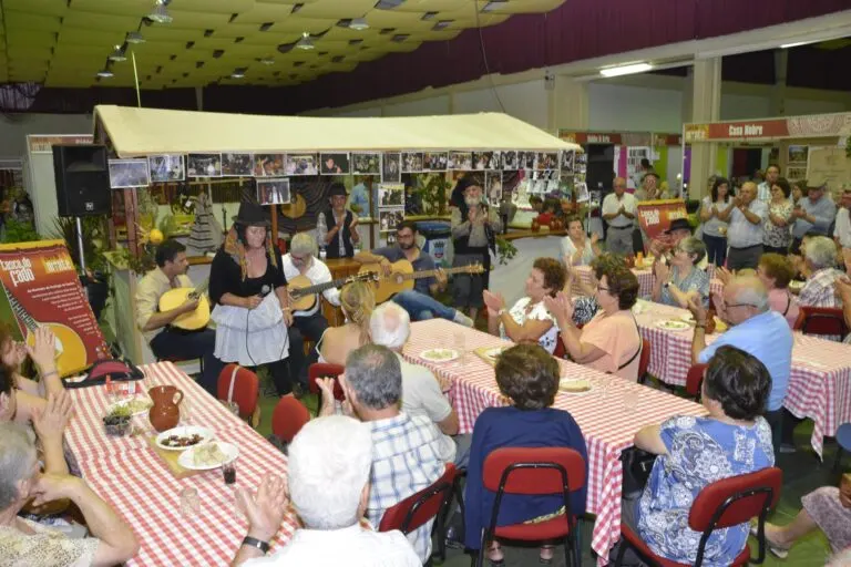 Atuação de fado para o público sentado às mesas num pavilhão da Feira do Monte
