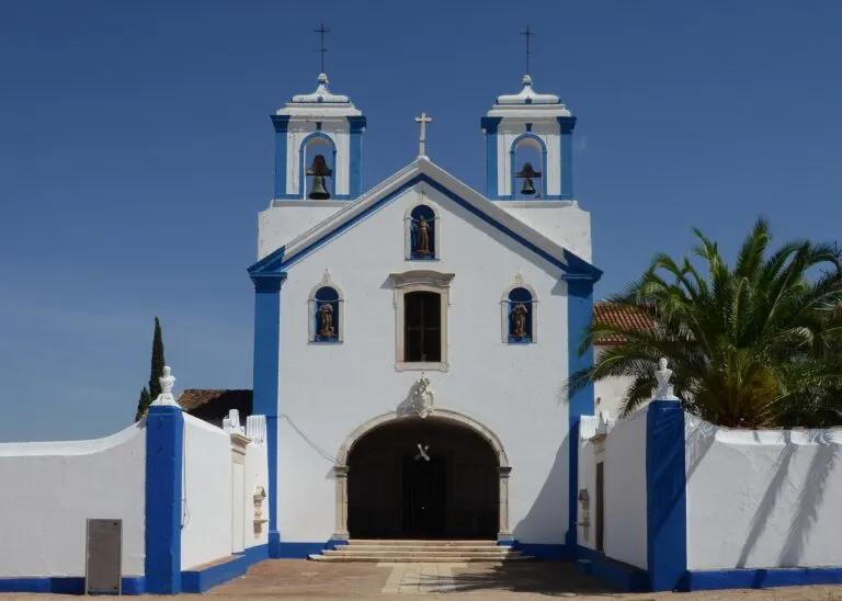 Fachada branca e azul da igreja do Convento dos Capuchos, em Vila Viçosa, com as duas torres sineiras