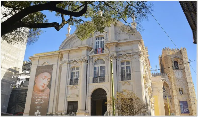 Fachada da Igreja de Santo António, em Lisboa, com o painel «Aqui nasceu Santo António» e a torre da Sé ao lado