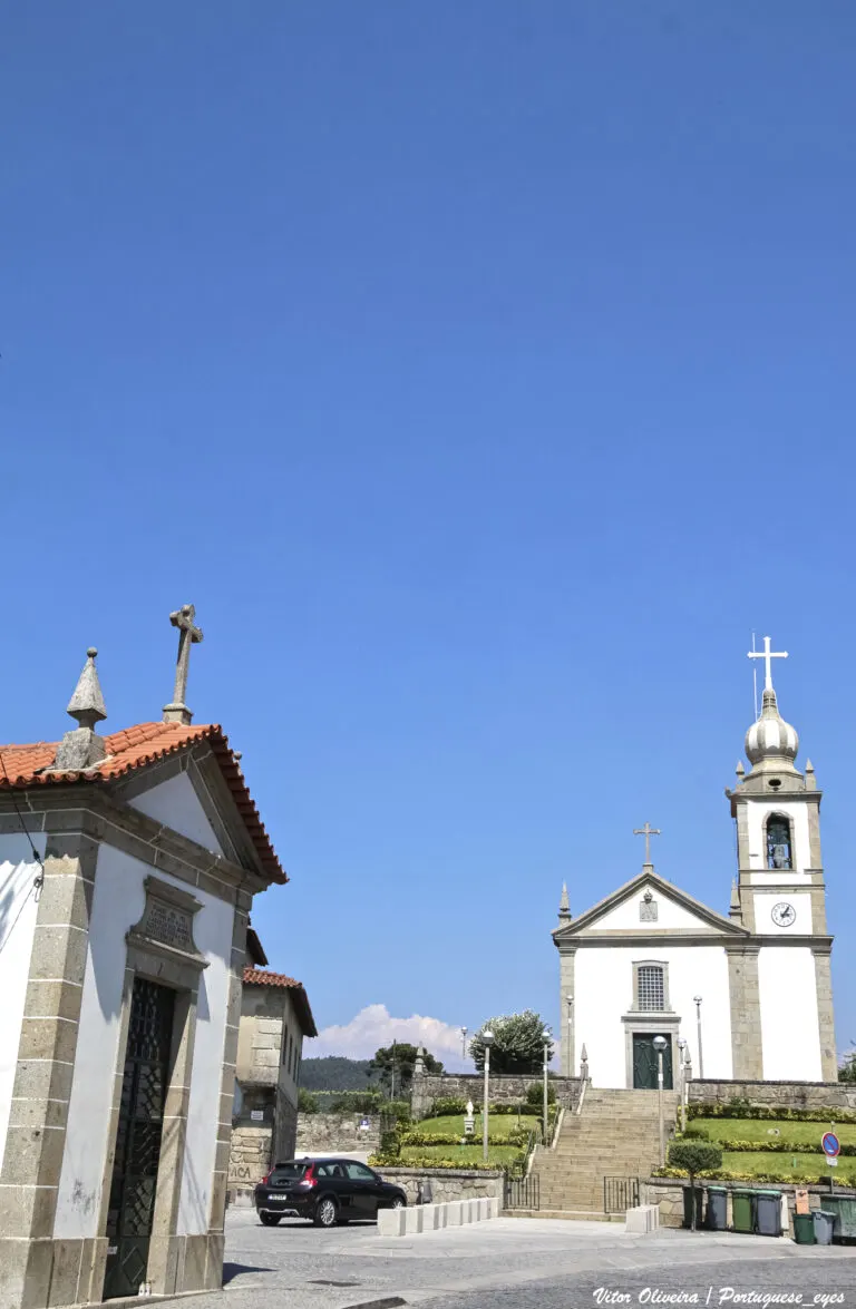 Igreja paroquial de Ferreiros, em Amares, vista do largo, com uma capela em primeiro plano
