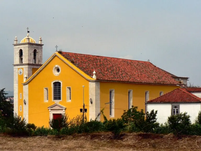 Vista lateral da Igreja Matriz de Loures, com o telhado de telha e a torre sineira