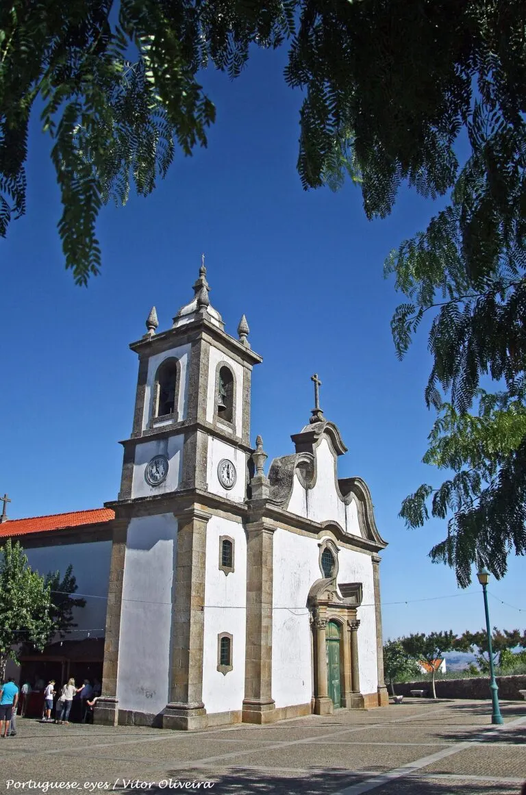 Fachada da Igreja Matriz de Sambade e o largo em frente, entre árvores