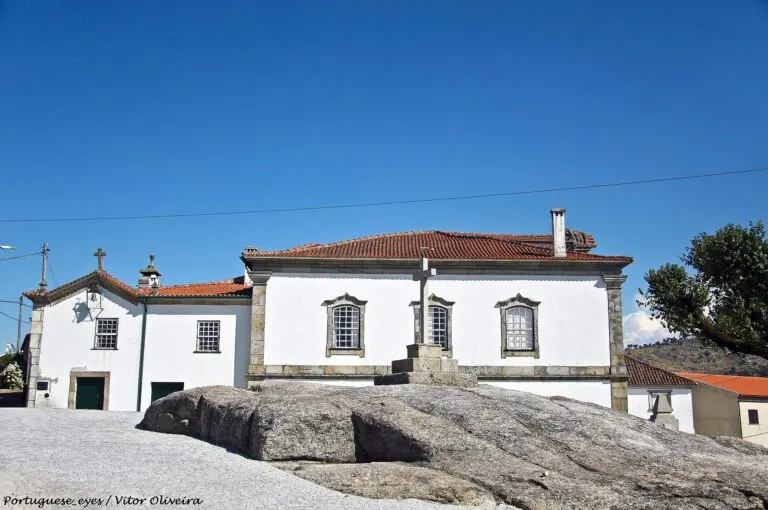 Casas caiadas e um cruzeiro sobre um afloramento de granito em Lajeosa do Mondego