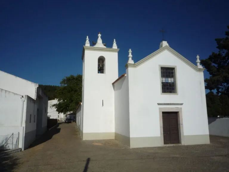 Fachada branca da igreja de Marmelete, com a torre sineira à esquerda