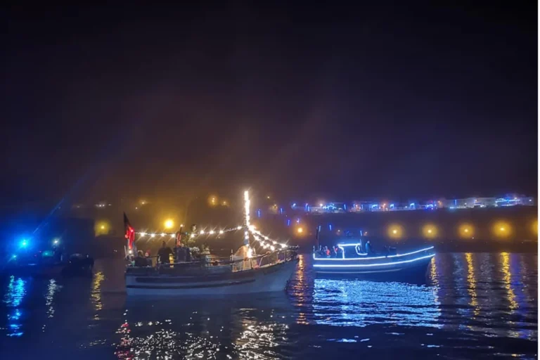 Barcos iluminados na procissão marítima noturna de 2022, no porto da Ericeira