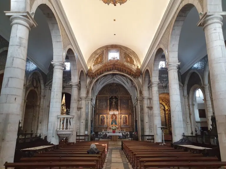 Nave do Santuário de Nossa Senhora da Conceição, em Vila Viçosa, com colunas de mármore e a imagem da Senhora no altar-mor