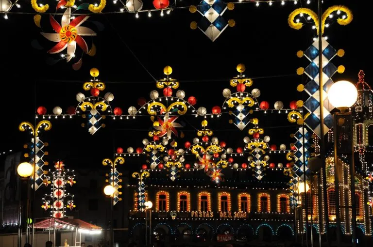 Iluminações tradicionais do São João de Braga, com cata-ventos e losangos de luz e a inscrição «Festas de S. João» num edifício iluminado