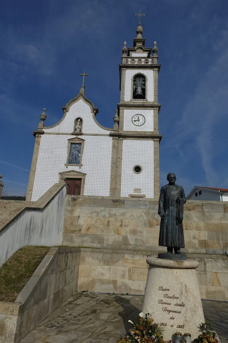 Igreja paroquial de Galegos São Martinho vista do adro, com a escadaria e a estátua do antigo pároco em primeiro plano
