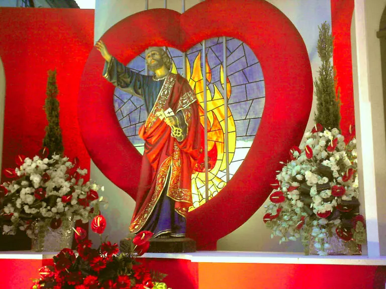 Trono de São Pedro do Bairro da Matriz, com a imagem do santo diante de um grande coração vermelho e arranjos de flores