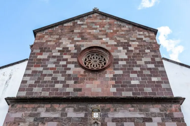Fachada da Sé do Funchal, em pedra de cantaria vermelha e escura, com a rosácea ao centro
